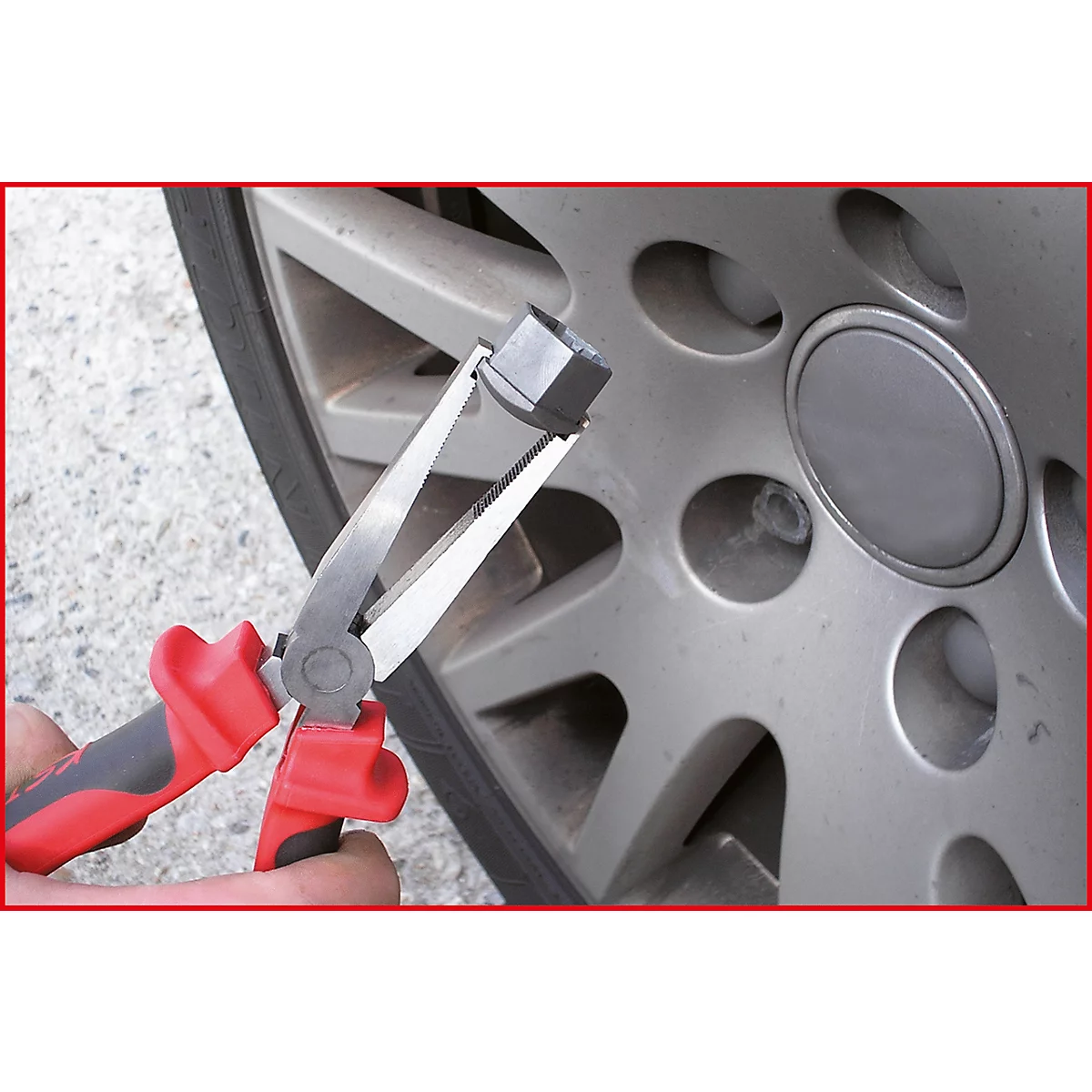 Zange hält eine Radmutter vor einem grauen Alurad.